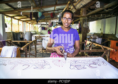 WELIGAMA, SRI LANKA - Jan 7, 2017: Alte Frau bei der Herstellung von Batik in Weligama auf Jan 7, 2017. Sri Lanka. Stockfoto