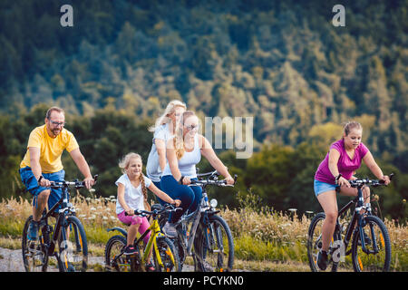 Familie Reiter ihre Fahrräder am Nachmittag in der Landschaft Stockfoto