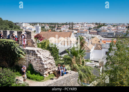 Touristen auf die alten Mauern der Burg von Tavira im Blick auf die historische Stadt im Hintergrund, Tavira, Algarve, Portugal Stockfoto