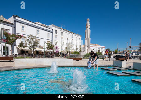 Besucher Abkühlung im Brunnen am Praça da Republica in der Stadt Tavira, Ostalgarve, Portugal Stockfoto