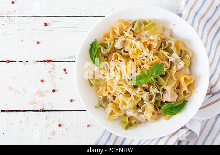 Cremige Nudeln mit Huhn und Aubergine diente in tiefen Teller. Italienisches Essen. Ansicht von oben. Flach. Stockfoto