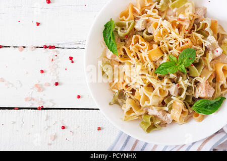 Cremige Nudeln mit Huhn und Aubergine diente in tiefen Teller. Italienisches Essen. Ansicht von oben. Flach. Stockfoto