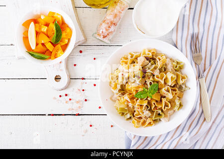 Cremige Nudeln mit Huhn und Aubergine diente in tiefen Teller. Italienisches Essen. Ansicht von oben. Flach. Stockfoto