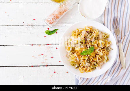 Cremige Nudeln mit Huhn und Aubergine diente in tiefen Teller. Italienisches Essen. Ansicht von oben. Flach. Stockfoto