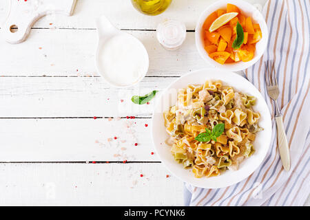 Cremige Nudeln mit Huhn und Aubergine diente in tiefen Teller. Italienisches Essen. Ansicht von oben. Flach. Stockfoto