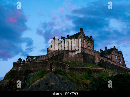 Das Edinburgh Castle Rock in der Dämmerung Sonnenuntergang mit dunkelblauen Himmel und rosa Wolken, Edinburgh, Schottland, Großbritannien Stockfoto