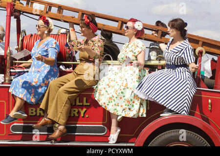 Frauen gekleidet in den vierziger Jahren Kleidung, sitzen auf einem vintage Kriegszeiten Fire Engine Stockfoto