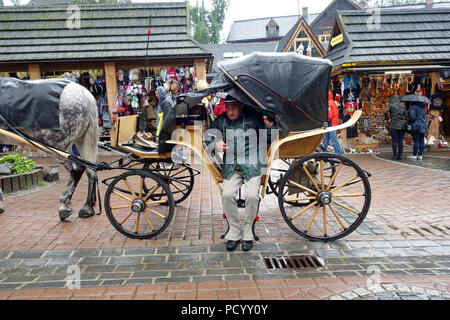 Schutz vor dem Regen Pferd und Trainer Mann in polnischen Highlander Kostüm in Zakopane Polen gekleidet Stockfoto