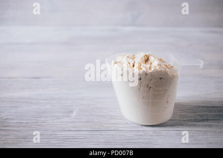 Protein Pulver in Schaufel auf weißer Tisch. Sport Nahrungsergänzung Bild mit kopieren. Stockfoto