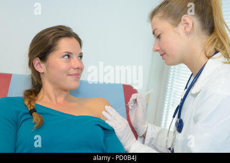 Physiotherapeut Einspritzen der Patientin in der Klinik Stockfoto