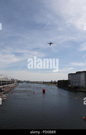 Ein Flugzeug vom Flughafen London City und fliegen über Schwimmer in London Docklands im Excel Center Stockfoto