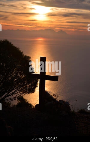 Südafrika. Kreuz Silhouette gegen Sonnenuntergang über die False Bay und den Tafelberg in der Nähe von Kapstadt. Stockfoto