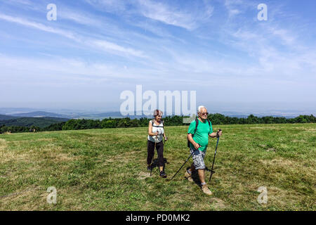 Ein älteres Ehepaar, Senioren mit Nordic Walking Stöcken auf einem Berg Trail, Veľká Javorina, tschechische Grenze zur Slowakei, Weiße Karpaten Stockfoto