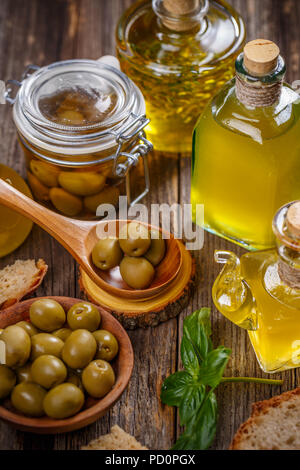 Noch immer leben Von olive Beeren und eine Flasche Olivenöl auf dem Vintage Holztisch Stockfoto