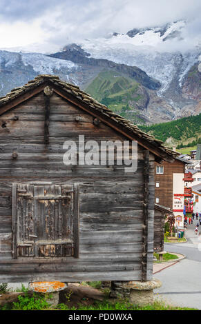 Traditionelle hölzerne Hütte auf staddle Steine am Eingang zu Saas Fee Dorf im Saastal (Saastal) im Kanton Wallis, Schweiz Stockfoto