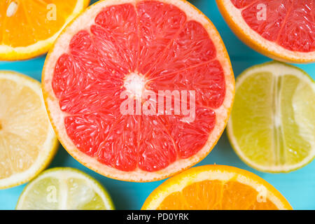 Saftige reife halbieren Ruby Grapefruit von cut Limonen-, Zitronen- und Orangenbäumen umgeben in einem full frame Ansicht von oben Stockfoto