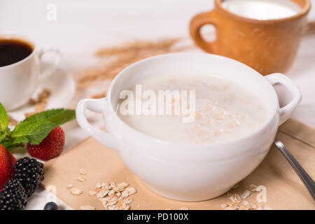 Schüssel mit Haferflocken porridge gegen Frühstückstisch in der Nähe zu sehen. Stockfoto