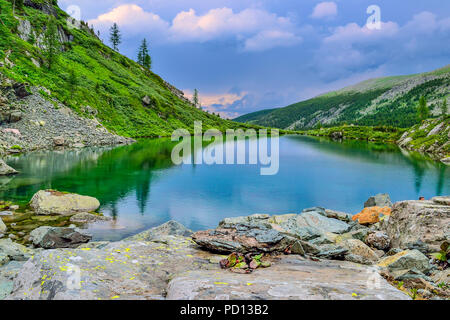 Eine aus sieben sauberste Berg Karakol Seen, im Tal, am Fuße der Bagatash Pass, Altai Gebirge, Russland. Grüne Hänge und Clo Stockfoto