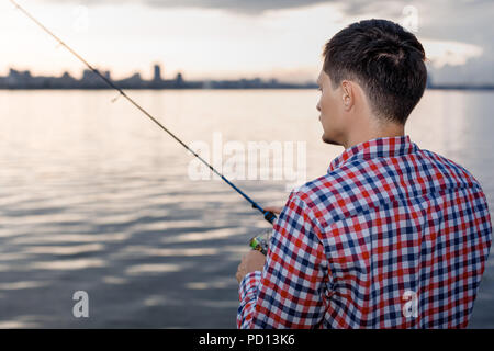 Angeln im Fluss bei Sonnenuntergang. Stockfoto