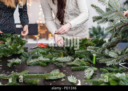 Hersteller von Weihnachten Kranz aus Zweigen von Pinien für Urlaub. Master Class auf dem Bilden der dekorativen Ornamenten. Weihnachten Einrichtung mit Ihren eigenen Händen. Das neue Jahr feiern. Flower Shop Stockfoto