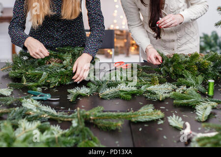 Hersteller von Weihnachten Kranz aus Zweigen von Pinien für Urlaub. Master Class auf dem Bilden der dekorativen Ornamenten. Weihnachten Einrichtung mit Ihren eigenen Händen. Das neue Jahr feiern. Flower Shop Stockfoto