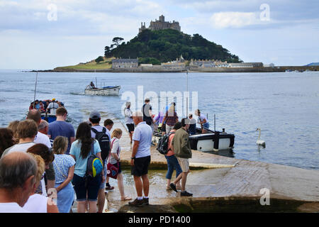 Warteschlangen von Touristen warten auf eine Fähre nach St. Michael's Mount, Marazion, Cornwall, UK - Johannes Gollop transportiert werden Stockfoto