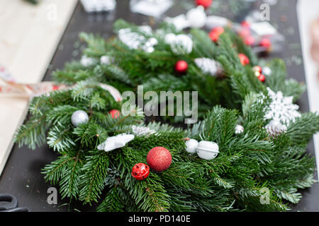 Hersteller von Weihnachten Kranz aus Zweigen von Pinien für Urlaub. Master Class auf dem Bilden der dekorativen Ornamenten. Weihnachten Einrichtung mit Ihren eigenen Händen. Das neue Jahr feiern. Flower Shop Stockfoto