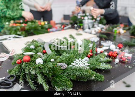 Hersteller von Weihnachten Kranz aus Zweigen von Pinien für Urlaub. Master Class auf dem Bilden der dekorativen Ornamenten. Weihnachten Einrichtung mit Ihren eigenen Händen. Das neue Jahr feiern. Flower Shop Stockfoto