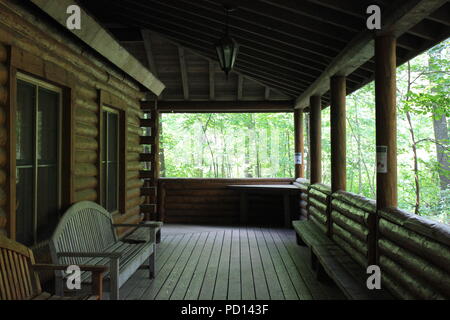 Riesige Veranda auf einer Blockhütte in der Mitte der Wiese. Stockfoto