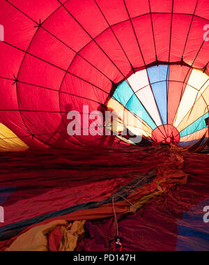 Der Schatten von zwei Personen die Kontrolle einer bunten Heißluftballon wie aufgeblasen wird. Stockfoto