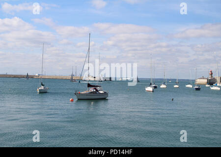 Der Eingang zu Dun Laoghaire Hafen mit Yachten in den Hafen und Fähre verlassen den Hafen von Dublin im Hintergrund. Stockfoto