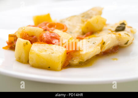 Fischgericht, Kabeljau mit Tomaten, Kartoffeln und Kapern, in einem Topf gekocht. Stockfoto