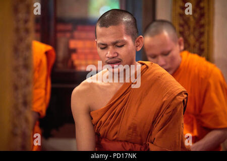 Ein junger buddhistischer Mönch singen mit seinen Augen während einer Zeremonie in einem der Tempel in ihrem Kloster geschlossen. Stockfoto