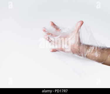 Männliche Hand kämpfen gegen Plastikbeutel Stockfoto