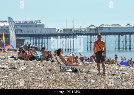 Brighton, Großbritannien - 5 August 2018 die Sonnenanbeter unter den Müll auf Brighton Beach am Morgen nach der jährlichen Pride Parade und Party. Es wird geschätzt über 250000 Menschen die Parade und Britney Spears Konzert am Samstag sorgte aber kämpfte, um nach Hause zu kommen, weil der Bahnhof hatte aus Gründen der Sicherheit aufgrund der Zahlen, die versuchen, die Züge zu fangen, geschlossen zu werden. Foto von Simon Dack Stockfoto