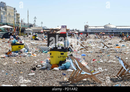 Brighton, Großbritannien - 5 August 2018 die Sonnenanbeter unter den Müll auf Brighton Beach am Morgen nach der jährlichen Pride Parade und Party. Es wird geschätzt über 250000 Menschen die Parade und Britney Spears Konzert am Samstag sorgte aber kämpfte, um nach Hause zu kommen, weil der Bahnhof hatte aus Gründen der Sicherheit aufgrund der Zahlen, die versuchen, die Züge zu fangen, geschlossen zu werden. Foto von Simon Dack Stockfoto