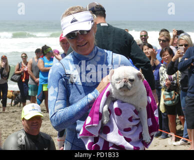 Pacifica, USA. 04 Aug, 2018. Alecia Nelson trocknet Ihr Hund Gidget nach dem Wettbewerb. Zahlreiche große und kleine Hunde in der 'World Dog Surfen Meisterschaften teilgenommen" in der Nähe von San Francisco. Quelle: Barbara Munker/dpa/Alamy leben Nachrichten Stockfoto