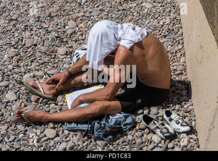 Sidmouth, Großbritannien 5. Aug. 18 Ein Mann cool am Strand hält in Sidmouth, da die Temperaturen wieder auf dem Devon Coast anzusteigen. Foto Central/Alamy leben Nachrichten Stockfoto