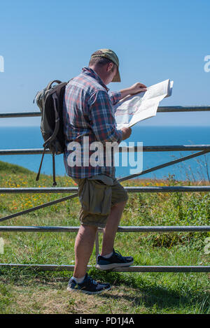 Sidmouth, East Devon, Großbritannien. 5. August 2018. UK Wetter: Sonnenschein und blauer Himmel im East Devon. Ein Wanderer berät seine Karte, wie er genießt die schöne Landschaft und die Küstenlandschaft entlang des South West Coast Path in der Nähe von Sidmouth an einem sehr heißen und sonnigen Tag. Credit: Celia McMahon/Alamy leben Nachrichten Stockfoto
