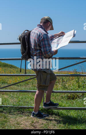 Sidmouth, East Devon, Großbritannien. 5. August 2018. UK Wetter: Sonnenschein und blauer Himmel im East Devon. Ein Wanderer berät seine Karte, wie er genießt die schöne Landschaft und die Küstenlandschaft entlang des South West Coast Path in der Nähe von Sidmouth an einem sehr heißen und sonnigen Tag. Credit: Celia McMahon/Alamy leben Nachrichten Stockfoto