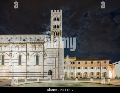 Schöne Nacht Blick auf die Kathedrale von San Martino mit bewölktem Himmel, von dem der Mond erscheint, Lucca, Toskana, Italien Stockfoto