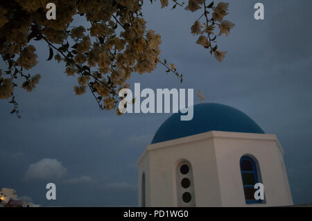 Weiß getünchten Kirche auf Klippen mit Meerblick und Blumen in Oia, Santorini, Kykladen, Griechenland Stockfoto