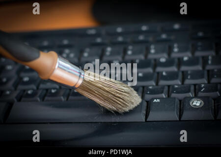 Reinigung Tastatur vor Staub von Schwarz & braun Bürste. Reinigung Konzept. Büro Reinigung. Stockfoto
