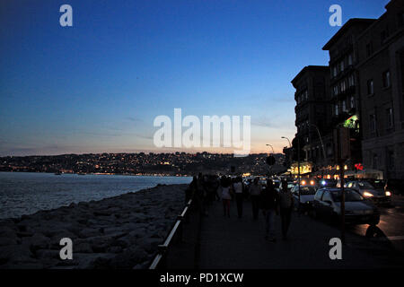 Viele Leute an der Promenade von Napoli, Italien bummeln, während Verkehr hetzt, um entlang der Küste Boulevard Stockfoto