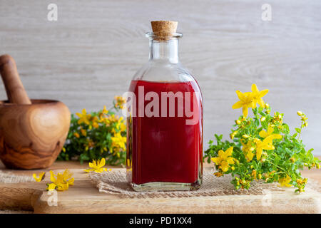 Eine Flasche roten Öl aus Johanniskraut Blüten erfolgen Stockfoto