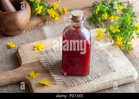 Eine Flasche roten Öl aus Johanniskraut Blüten erfolgen Stockfoto