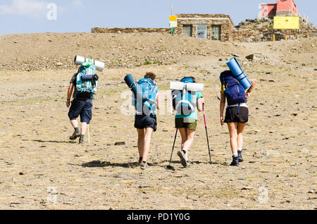 Wanderer mit Rucksäcken hinauf zum Pico veleta Gipfel, Sierra Nevada, in der Sommersaison. Granada, Andalusien, Spanien. Stockfoto