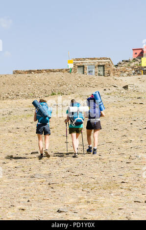 Wanderer mit Rucksäcken hinauf zum Pico veleta Gipfel, Sierra Nevada, in der Sommersaison. Granada, Andalusien, Spanien. Stockfoto