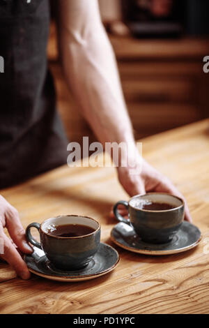 Ein Kellner wird den Kaffee zu servieren. gut vorbereitete trinken. Bis schließen Seitenansicht erschossen. Joe Konzept Stockfoto