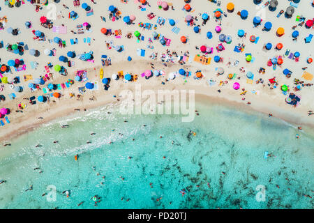 Luftaufnahme der Sandstrand mit bunten Sonnenschirmen, Schwimmen im Meer Bucht mit transparenten blauen Wasser im sonnigen Morgen im Sommer. Reisen in Mallo Stockfoto